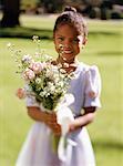 Portrait de jeune fille tenant des fleurs à l'extérieur