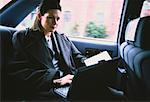Businesswoman Using Laptop Computer in Taxi