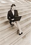 Businesswoman Sitting on Steps Using Laptop Computer