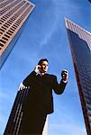 Businessman Using Cell Phone and Pager Outdoors