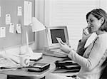 Femme d'affaires en utilisant le téléphone sans fil au bureau
