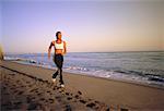 Woman Running on Beach in Athletic Wear