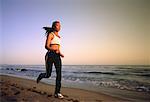 Woman in Athletic Wear, Running On Beach