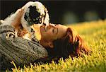 Woman Lying in Field with Dog