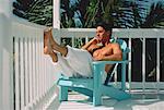 Homme assis dans une chaise longue sur le balcon