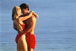 Couple in Swimwear, Embracing On Beach