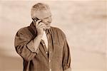 Mature Man Using Cell Phone on Beach