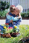 Großmutter und Enkelin umarmen im Garten