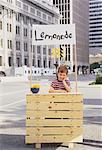 Junge mit Lemonade Stand im Geschäftsviertel