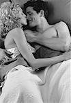 Couple couché dans son lit, s'embrasser
