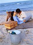 Couple Having Picnic, Kissing on Beach