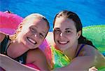 Portrait of Teenage Girls with Inner Tubes in Swimming Pool