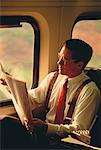 Businessman Reading Newspaper on Train