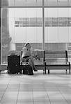 Geschäftsfrau, die auf Bank mit Gepäck in Terminal Toronto, Ontario, Kanada