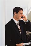 Businessman Using Cell Phone Holding Agenda