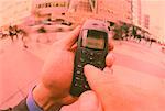 Close-Up of Hands Holding Cell Phone on Street