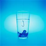 Coins and Fish Hook in Glass of Water