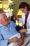 Arzt unter Berücksichtigung älterer Mann Blutdruck im Krankenhausbett