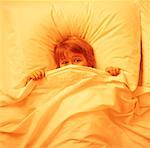 Boy in Bed Covering Face with Sheets