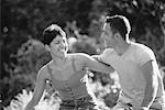 Couple Riding Bicycles Arm in Arm In Park