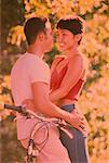 Couple Leaning on Bicycle Embracing Outdoors
