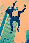 Ecstatic Businessman Jumping in Air Outdoors