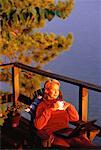 Mature Woman with Laptop Computer And Coffee Mug on Sundeck