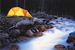 Rougeoyant tente près de cours d'eau des montagnes Rocheuses, Parc National Banff, Alberta, Canada