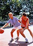 Mature Couple Playing Basketball In Park