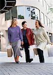 Three Women Walking up Steps Carrying Shopping Bags