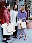 Three Women Standing on Street Holding Shopping Bags