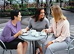 Drei Frauen im Gespräch bei Outdoor-Café