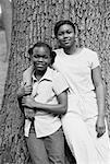 Portrait of Two Girls Standing Near Tree