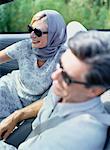 Mature Couple Sitting in Convertible, Wearing Sunglasses