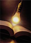 Lightbulb Hanging Over Open Book