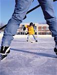 Father and Son Playing Hockey on Outdoor Ice Rink
