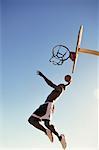 Homme sautant dans l'Air extérieur de basket-ball