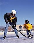 Father and Son Playing Hockey At Outdoor Ice Rink