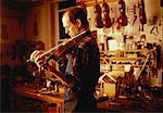 Luthier Playing Violin in Workshop