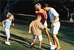 Family Playing with Soccer Ball In Park