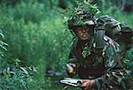Soldier Wearing Camouflage Holding Map in Jungle