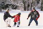 Famille marchant dans le champ de neige profonde