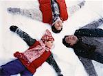 Overhead View of Family Lying in Snow, Making Snow Angels