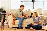 Couple Relaxing at Home with Laptop and Book