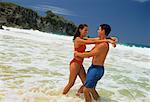 Couple en maillot de bain, embrassant dans le Surf sur la plage, République dominicaine, Caraïbes