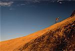 Man Riding Mountain Bike Hill Moab, Utah, USA