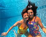 Portrait of Two Women Underwater In Swimming Pool