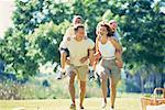 Mother and Father Carrying Son And Daughter on Backs Outdoors