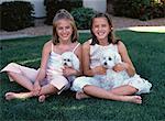 Portrait of Two Girls Sitting Outdoors with Dogs