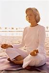 Ältere Frau tun Yoga am Strand bei Sonnenuntergang, Florida, USA
